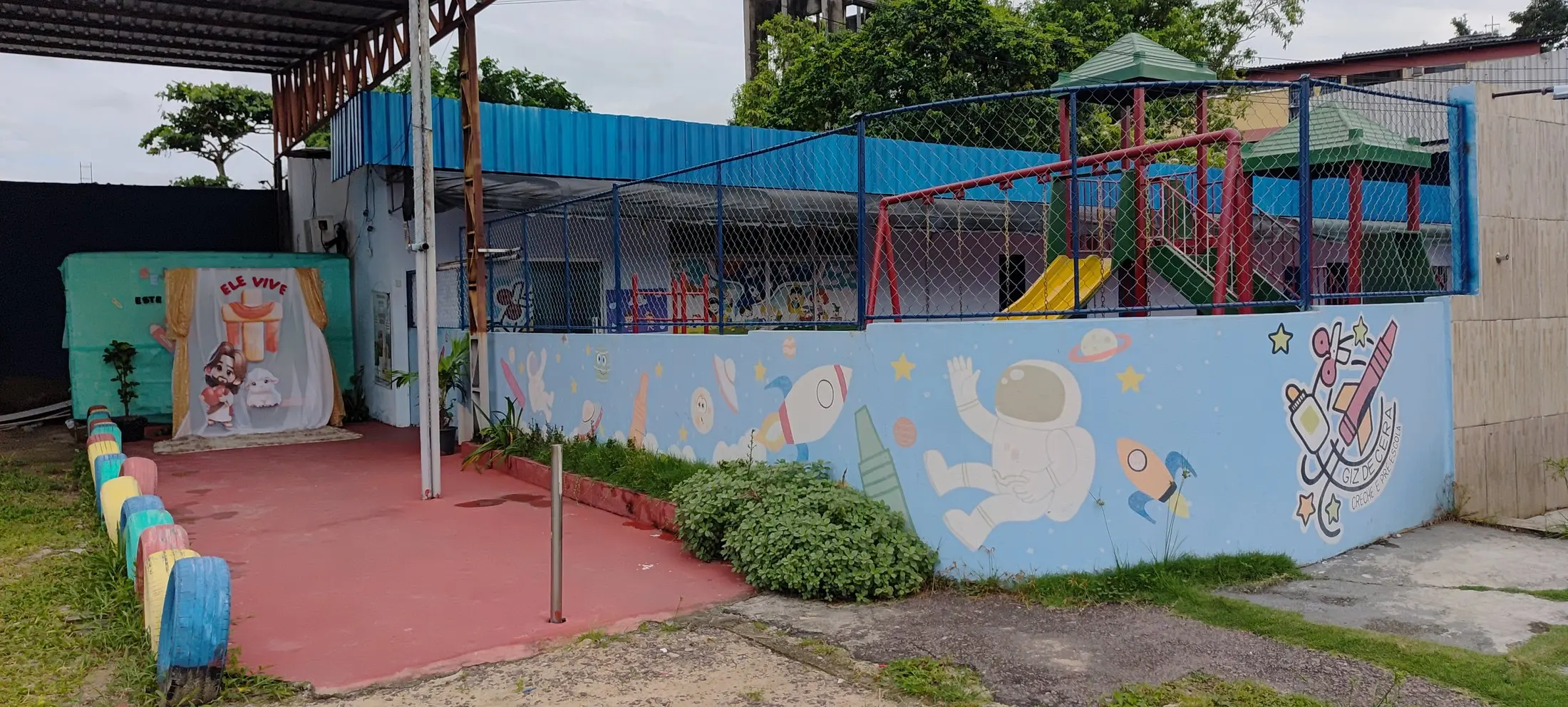 Pátio fechado com o muro pintado com um astronauta e um foguete de giz